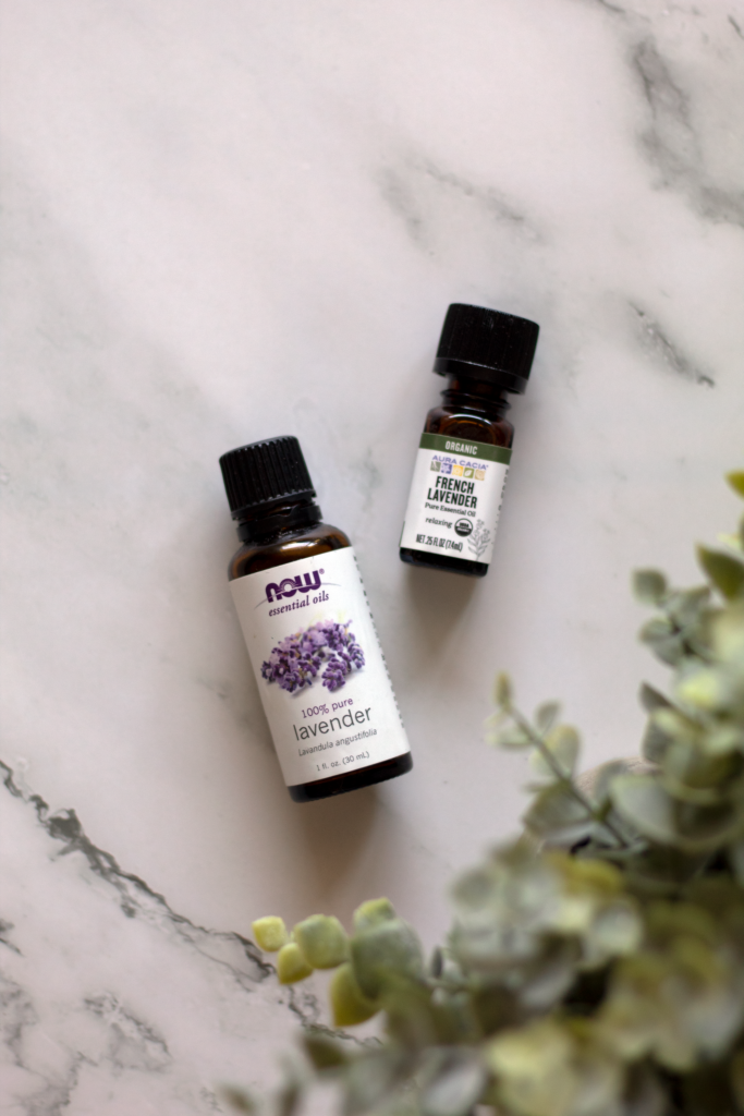 Two small bottles of lavender oil on a marble table to relax