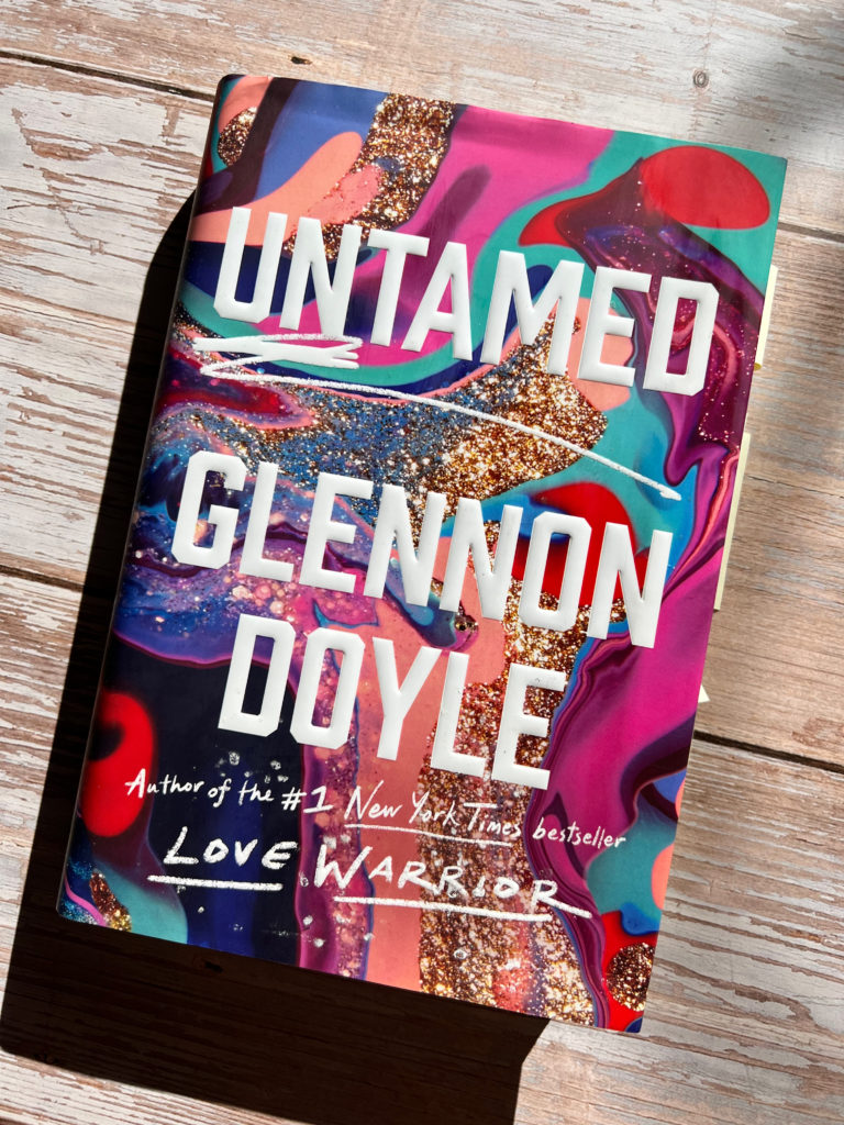 The cover of Glennon Doyle's book "Untamed" on a wood table to relax