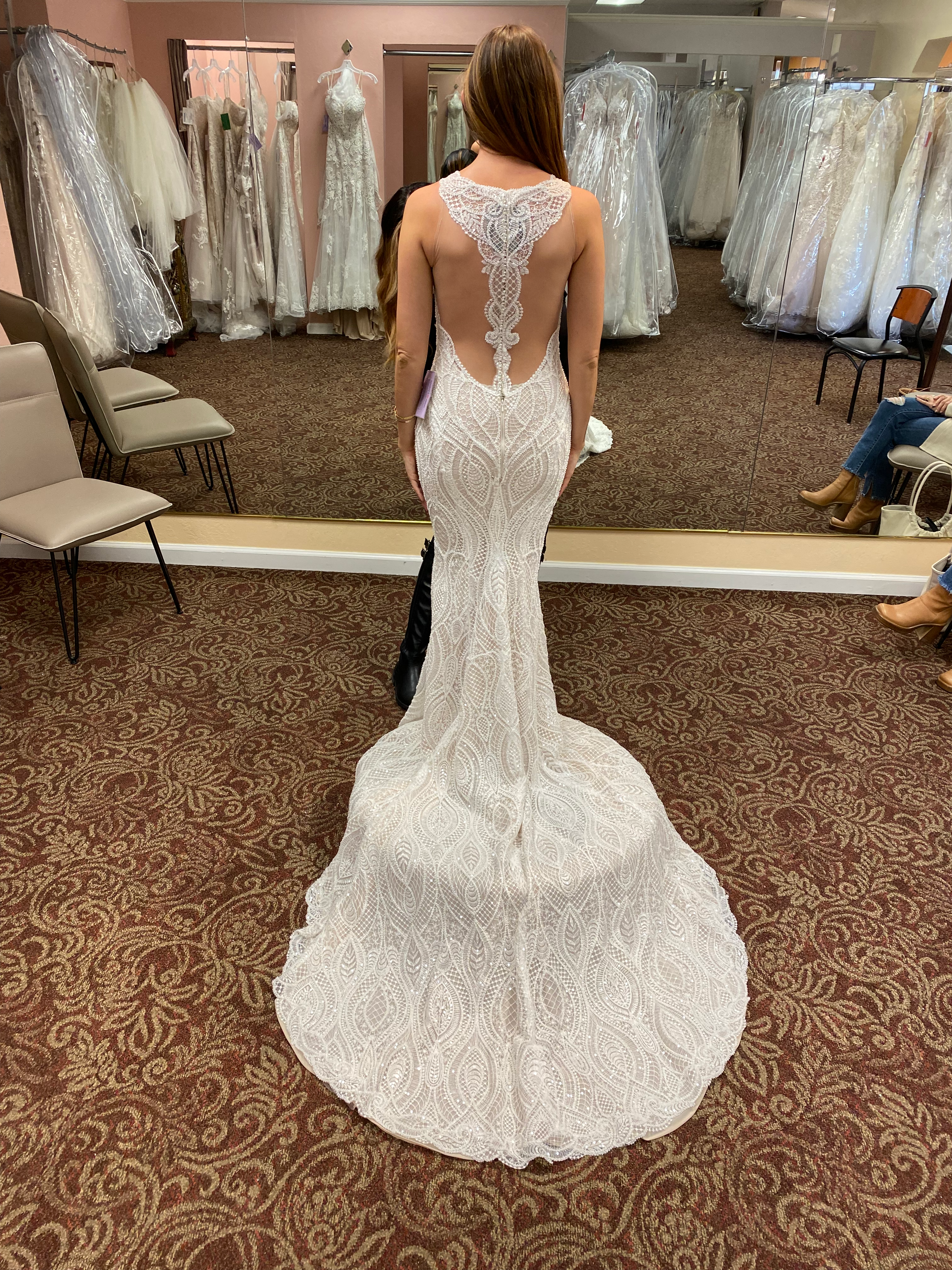The back of Tara's wedding dress as she's in a bridal boutique looking forward into a mirror.