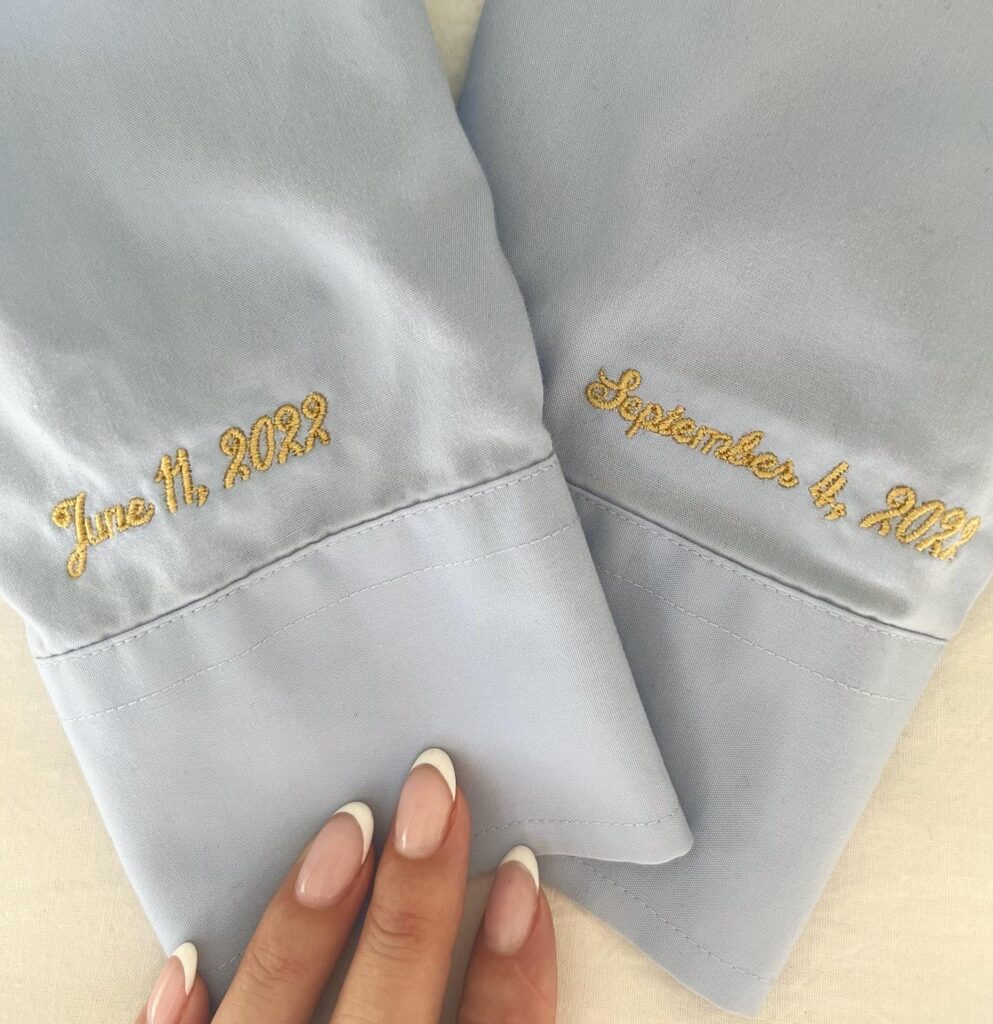 Light blue shirt sleeves with gold monogramming.