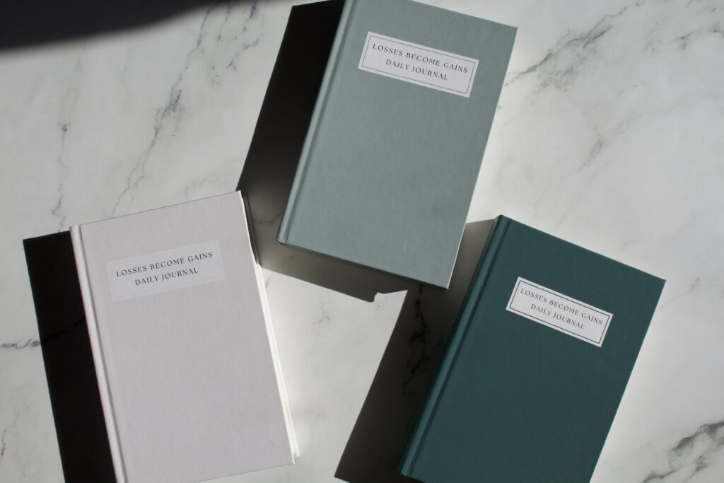 Three journals laying on a white background next to each other